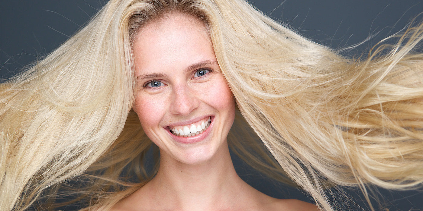 Blonde Frau mit offenem, voluminösem Haar als Symbol für frisches und leichtes Haar.